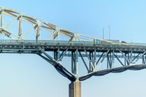Cyclists Celebrate Opening: Close-up view of vehicles crossing the steel truss structure under a clear blue sky in Corpus Christi, Texas.