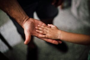 A child’s small hand rests gently in an adult’s open palm, symbolizing fatherhood and connection as Mauricio Dubón plays with new purpose.
