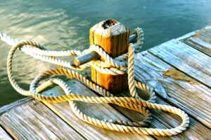 Rockport Man’s Death: A dock post with a mooring rope tied securely, overlooking the calm waters of Rockport Harbor at sunset.