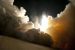 A massive rocket launches into the night sky, engulfed in smoke and fire—Starship Test Ends in Fireball, illuminating the dark backdrop.
