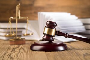 A judge’s gavel and legal scales rest on a wooden desk with law books in the background, as Texas Law Requires Ten Commandments.