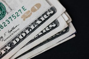 Close-up image of several folded twenty-dollar bills on a black surface, symbolizing financial issues as Corpus Council Slams OVG.