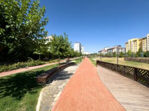 Corpus Christi Plans $20M park upgrades featuring wide walking and biking trails, green spaces, and community seating under a clear sky.