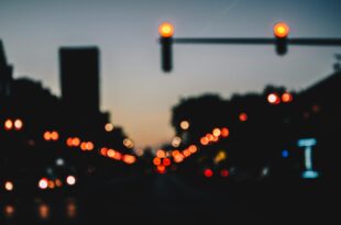 Blurred city street at dusk with glowing traffic lights, symbolizing Fatal crash at Nueces County and road safety awareness.