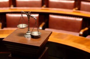 Scales of justice in a courtroom symbolize fairness and legal decisions as Kingsville recall dispute sparks ongoing controversy.