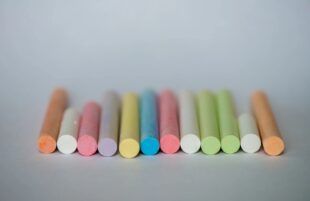 Colorful chalk sticks lined up on a light surface, representing education as Flour Bluff ISD approves staff raises and support.