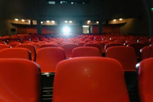 Cinergy Entertainment Breaks Ground with rows of red theater seats inside a cinema, ready for future movie screenings in Corpus Christi.