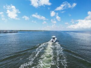 Boat cruising across Corpus Christi Bay under clear skies, highlighting coastal waters as Corpus Christi Council Faces a crucial vote.