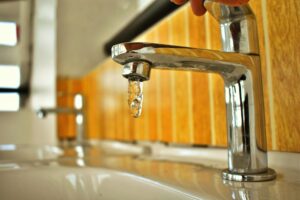 Corpus Christi faces key decisions on water rates as a drop of water falls from a chrome faucet in a household sink.