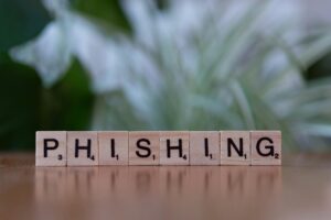 Wooden Scrabble tiles spell “Phishing,” symbolizing cyber fraud as Nueces County battles $2M email scam losses.