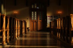 Revitalizing Uptown: A Historic cathedral interior with wooden pews, stained glass doors, and soft candlelight ambiance.