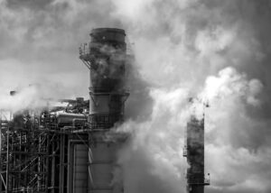 Nagasaki Survivors Share Stories industrial towers emit thick smoke into the sky, highlighting pollution and somber historical reflection.