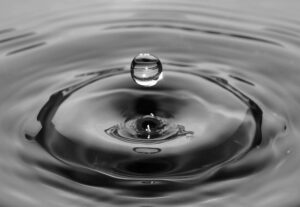 Close-up of a single water droplet creating ripples, symbolizing Corpus Christi’s water concerns as Moody’s Weighs Downgrade.