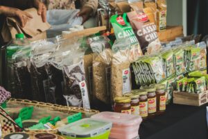 Bags of rice, grains, and canned goods displayed on a table at a donation drive for Coastal Bend Food Pantries.