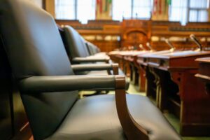 Leather courtroom chairs line a polished wooden chamber as desks and microphones sit ready for proceedings. Texas Attorneys Arrested
