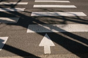 Crosswalk and directional arrow on roadway at dusk, symbolizing traffic safety in Port Aransas pedestrian crash investigation