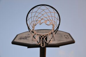 Low-angle view of a basketball hoop and net against clear sky, symbolizing game action and Houston Cougars intensity