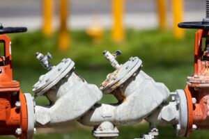 Close-up of industrial natural gas pipeline valves and fittings, representing the U.S. LNG export authorization infrastructure.