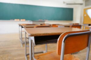 Empty classroom with desks and chalkboard highlighting Texas classroom screen time limits and a return to traditional learning.