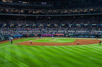 Crowd fills a baseball stadium during a live game as fans watch the action at the Banana Ball World Tour event.