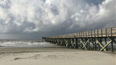 Storm clouds gather over Bob Hall Pier and rough coastal waves as weather delays inspections and Bob Hall Pier closure
