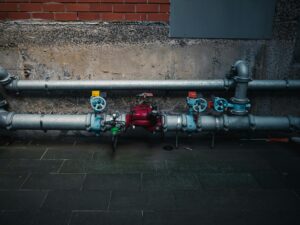 Industrial water pipes with valves along a wall, representing infrastructure for Corpus Christi desalination plant
