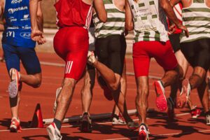 Houston Astros race runners compete on a crowded track during a community running event at a stadium finish line.