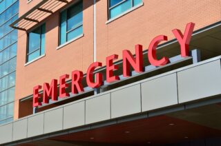 Hospital emergency department entrance with large emergency sign, representing the new Calallen emergency care facility.