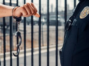 Corpus Christi ICE operation shows handcuffed individual beside a law enforcement officer during immigration arrest.