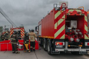 Firefighter hydration technology supports firefighter safety as crews work near fire trucks during emergency response.