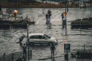 Flash flooding strands a vehicle on a flooded roadway as residents navigate rising waters during heavy rainfall.
