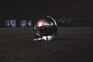 American football helmet on a field under stadium lights before kickoff in Houston, Texans, symbolizing NFL action.