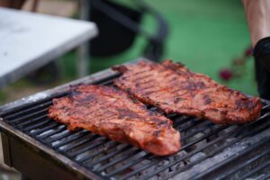 Texas Food Championship Corpus Christi features grilled meat cooking on an outdoor barbecue grill.