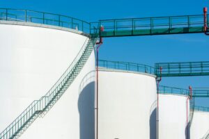 Large white industrial water storage tanks with metal stairways and pipes under a clear blue sky, highlighting Corpus Christi water security.